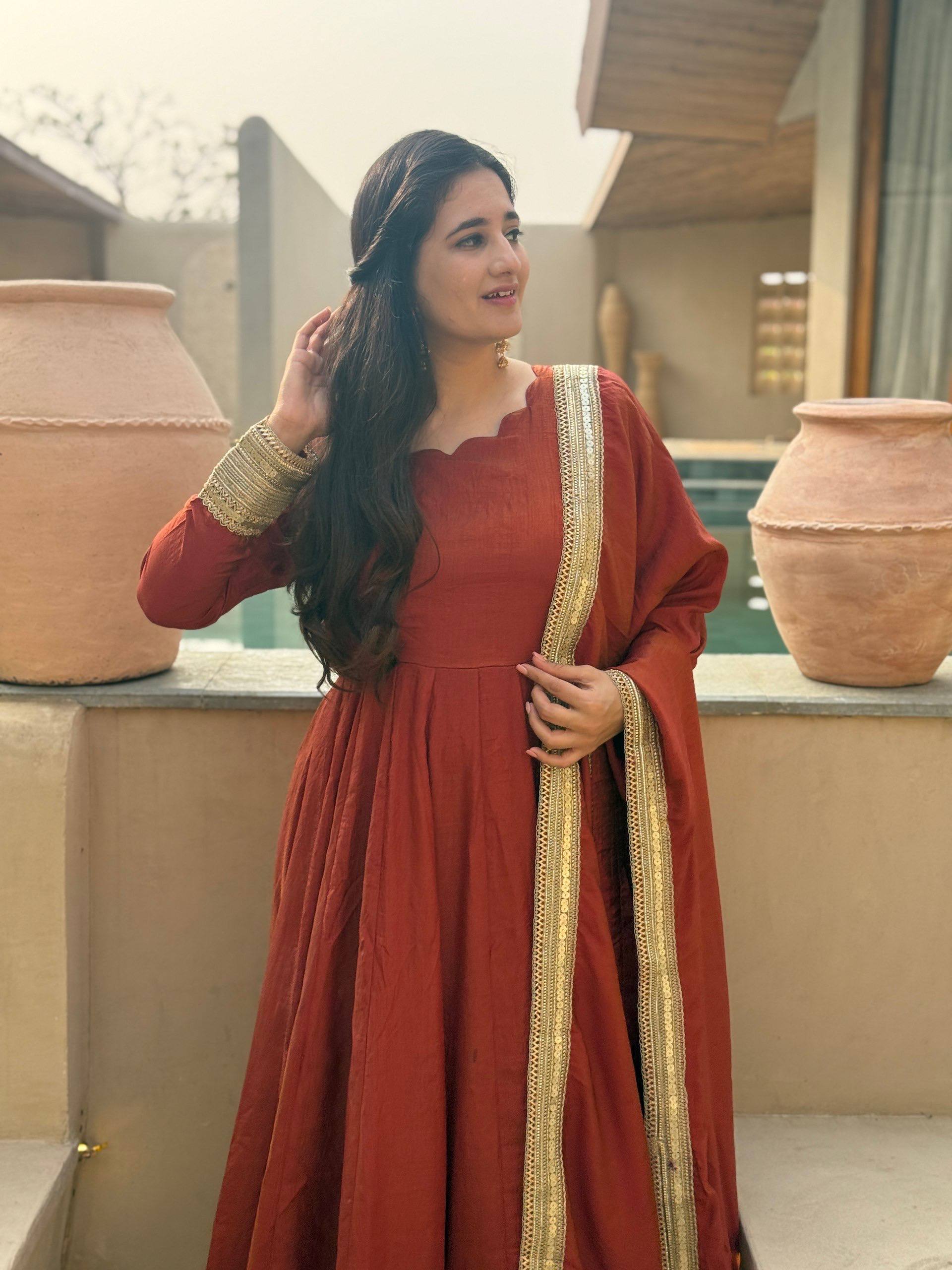 Regal Rust Orange Flared Anarkali Suit Set Featuring Ornate Gold Sequined Borders, a Scalloped Neckline, and an Elegant Tie-Up Back